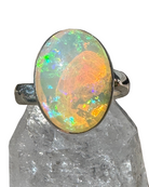 Opal ring with multicolored gemstone on a clear crystal base